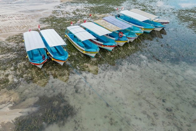 Vista aerea di una fila di barche da pesca in piedi sul fondo con la bassa marea