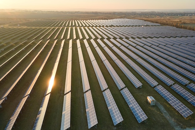 Vista aerea di una grande centrale elettrica sostenibile con file di pannelli fotovoltaici solari per la produzione di energia elettrica pulita la sera Concetto di elettricità rinnovabile a emissioni zero