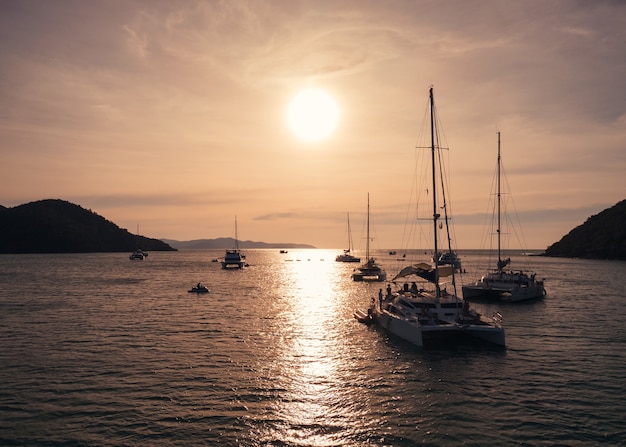 Vista aerea di yacht di lusso che navigano nel mare tropicale al tramonto. Concetto di vacanze e vacanze