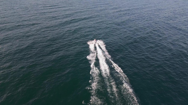 Vista aerea dinamica dello scooter acquatico o della moto d'acqua o del jet da sci che corre attraverso le onde del mare