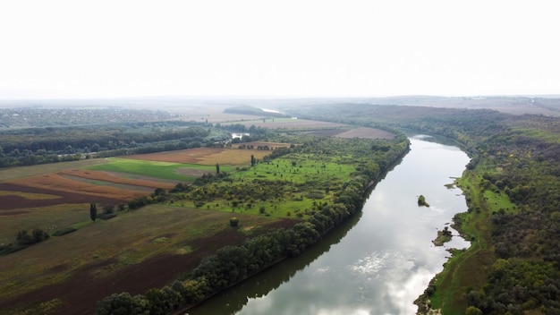 Vista aerea drone della natura in Moldova, fiume galleggiante con cielo riflettente, campi verdi con alberi, nebbia nell'aria