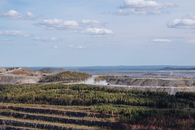 Vista aerea industriale della cava mineraria a cielo aperto con molti macchinari al lavoro - vista dall'alto. Estrazione di calce, gesso, calx, caol