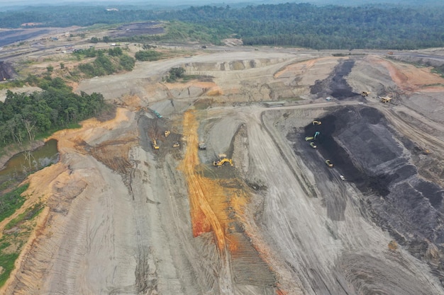 Vista aerea industriale di miniere di carbone a cielo aperto con molti macchinari al lavoro - vista dall'alto.