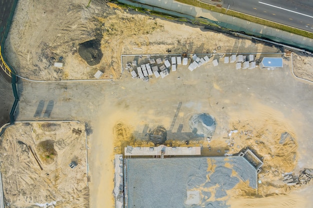 Vista aerea panoramica sulla fossa di fondazione il cantiere di montaggio di pareti in mattoni di cemento