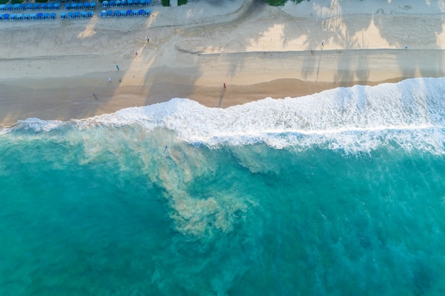 Vista aerea spiaggia di sabbia e onde Bellissimo mare tropicale al mattino immagine stagione estiva da vista aerea drone shot, alto angolo vista dall'alto verso il basso.