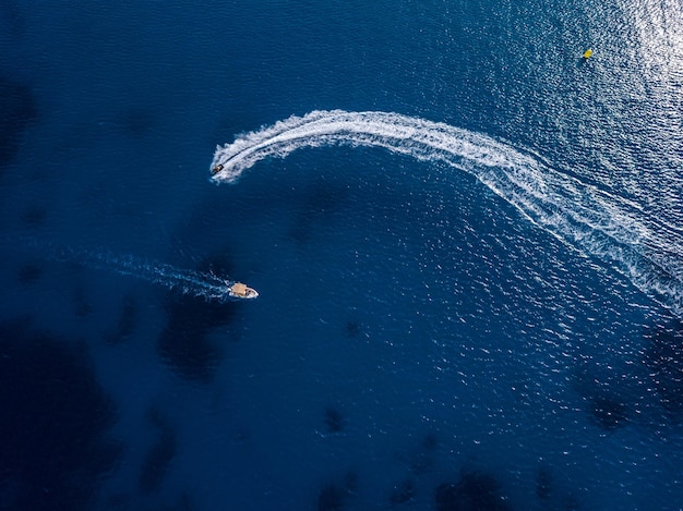 Vista aerea su moto d'acqua e motoscafo nelle acque blu tropicali