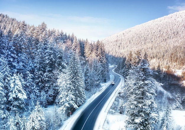 Vista aerea sulla strada e sulla foresta in inverno Paesaggio invernale naturale dall'aria Foresta sotto la neve e in inverno Paesaggio da drone