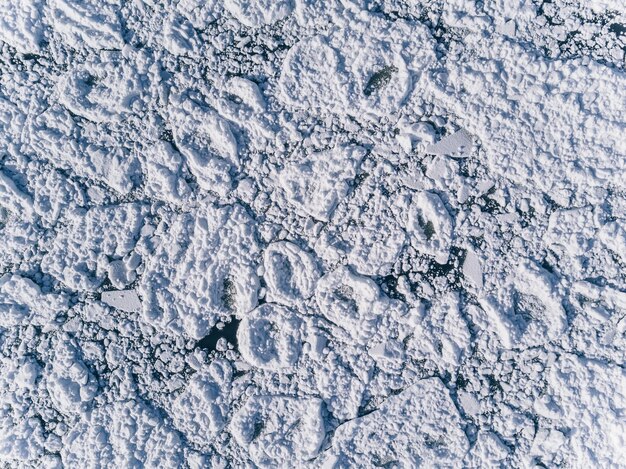 Vista aerea sulla superficie del mare e ghiaccio incrinato sotto la neve