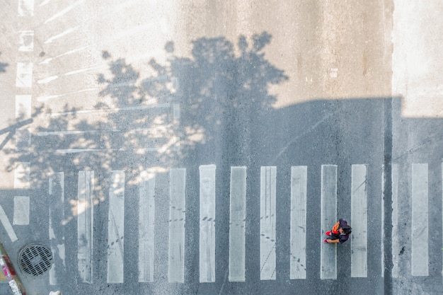 Vista aerea superiore Movimento di strisce pedonali pedonali o attraversamento pedonale. Piedi dei pedoni che attraversano sulla strada della città.