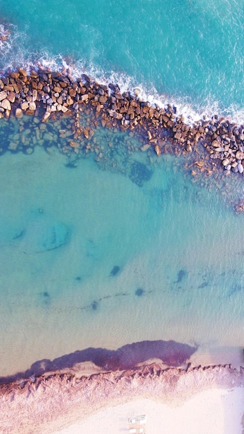 Vista aerea verticale di un bellissimo oceano e costa rocciosa in una giornata di sole
