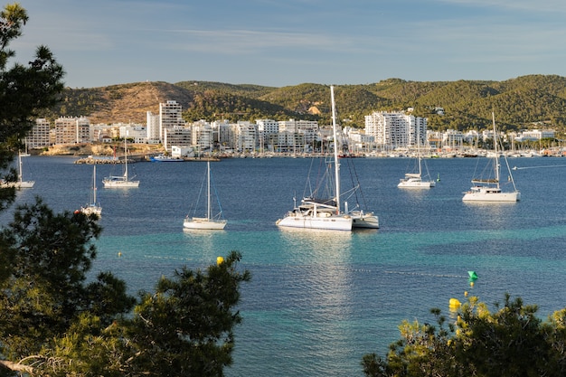 Vista al porto de sant antoni de portmany baia della costa di ibiza con acqua turchese e yacht o...