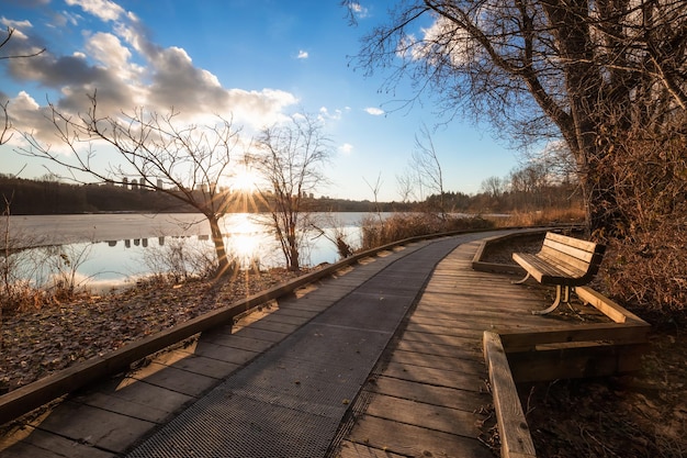 Vista al tramonto su un sentiero di legno a Deer Lake con Metrotown City in background