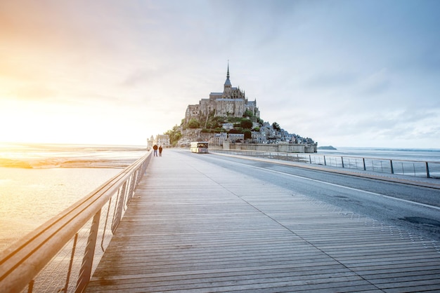 Vista al tramonto sulla famosa abbazia di Mont Saint Michel con ponte durante la marea in Francia