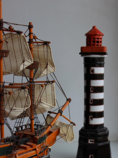 Vista angolare posteriore del modello in scala della nave a vela verso la torre del faro giocattolo