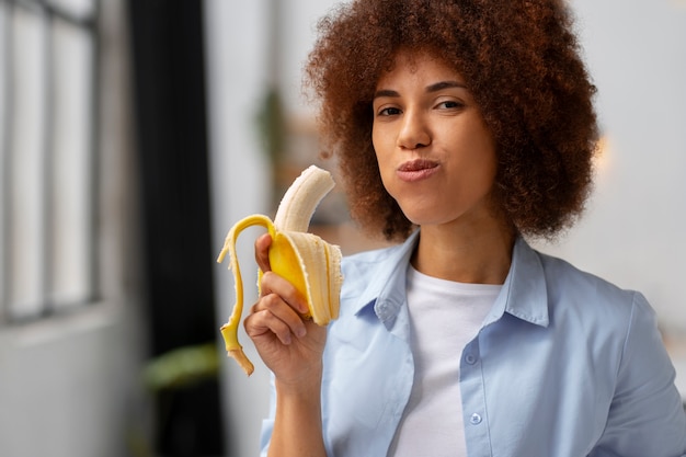 Vista anteriore donna che mangia banane
