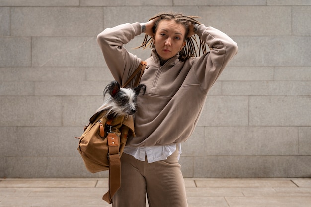 Vista anteriore donna che porta un cucciolo in borsa