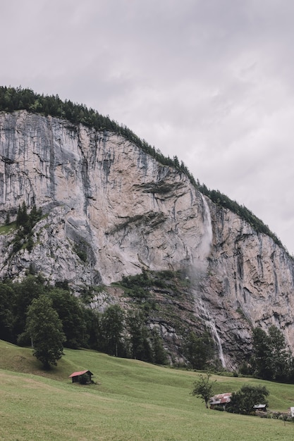 Vista cascata Staubbach caduta in montagna, valle delle cascate nella città di Lauterbrunnen, Svizzera, Europa. Paesaggio estivo, tempo soleggiato, cielo drammatico e giornata di sole