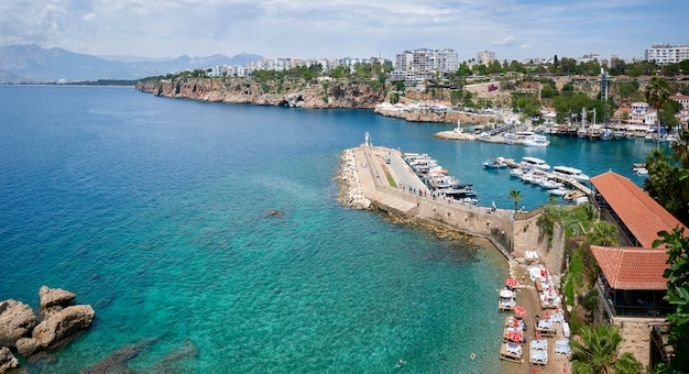 Vista costiera mozzafiato ad Antalya con faro blu dell'oceano e barca a vela