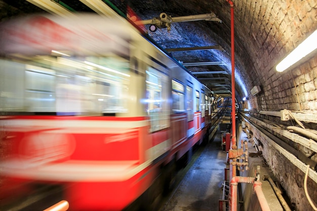 Vista cupa del tunnel della metropolitana con treno in movimento