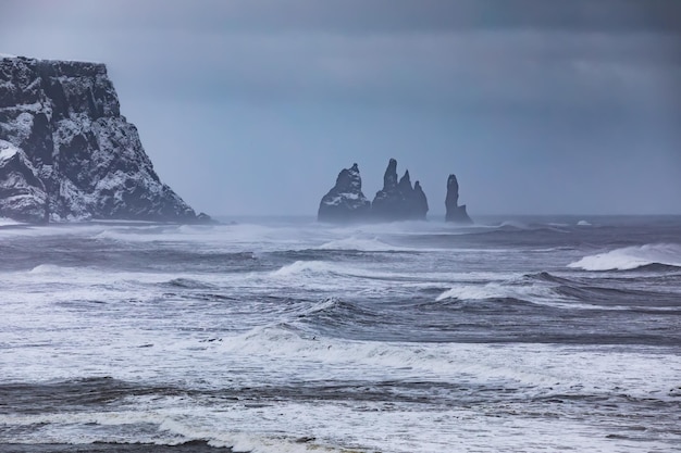 Vista da cape Dyrholaey sulla spiaggia di Reynisfjara e Reynisdrangar basalto pile di mare Islanda tempesta invernale