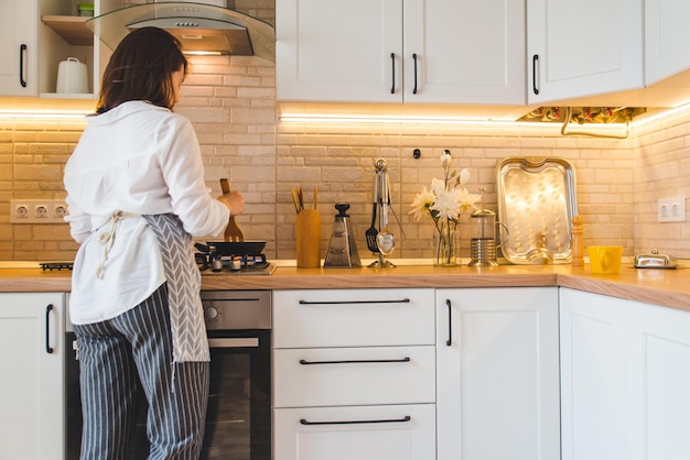 Vista da dietro la donna sulla cucina in cucina