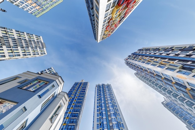 Vista da sotto nel cielo blu con le nuvole di un grande complesso residenziale moderno a grattacieli