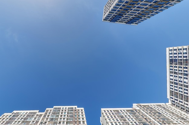 Vista da sotto nel cielo blu con le nuvole di un grande complesso residenziale moderno a grattacieli