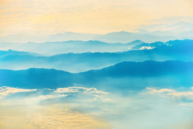 Vista da un aereo al tramonto sul cielo con i raggi solari. Sfondo di nuvole soffici