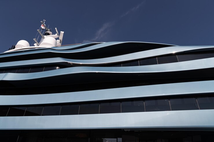 Vista dal basso dei ponti dell'enorme yacht di colore blu in una giornata di sole bordo lucido della barca a motore sun ref...