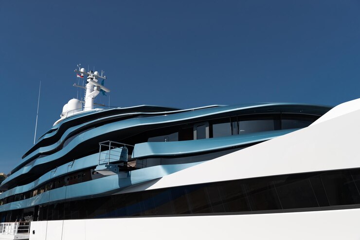Vista dal basso dei ponti dell'enorme yacht di colore blu in una giornata di sole bordo lucido della barca a motore sun ref...