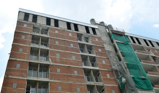 Vista dal basso di un alto edificio commerciale in costruzione contro un cielo blu