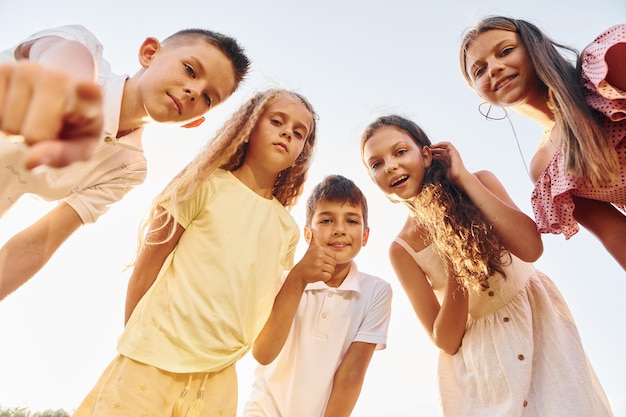 Vista dal basso di un gruppo di bambini che guardano in basso e si divertono