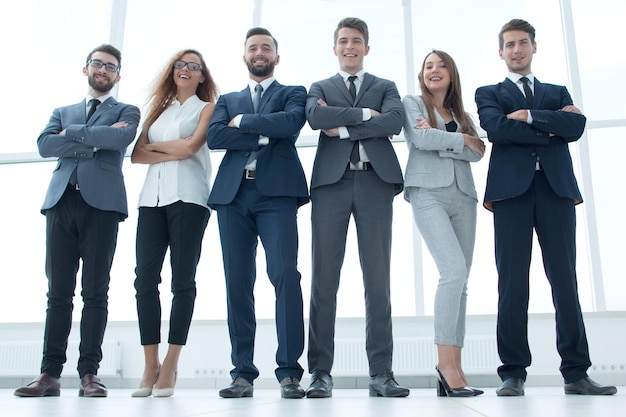 Vista dal basso squadra di affari di successo in piedi in un ufficio spazioso il concetto di lavoro di squadra
