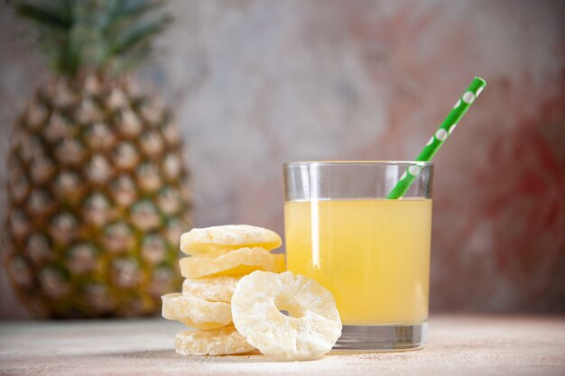 vista dal basso succo pipetta in vetro ananas secco anelli ananas isolato su sfondo beige