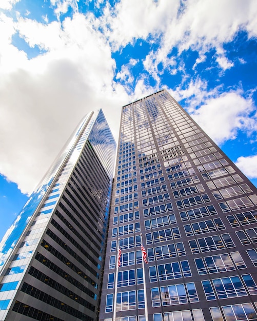 Vista dal basso sulla strada sul quartiere finanziario di Lower Manhattan, New York City, New York, Stati Uniti d'America. Grattacieli alti edifici di vetro negli Stati Uniti d'America. Cielo blu su sfondo. Posto vuoto per spazio di copia.