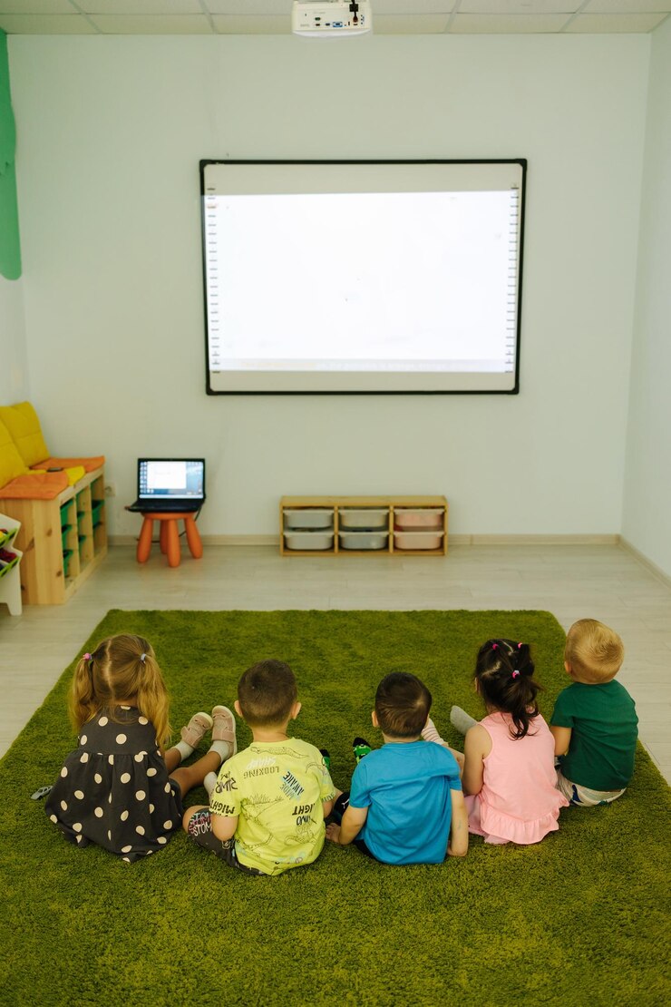 Vista dal retro quando i bambini guardano su un film d'animazione per bambini proiettore