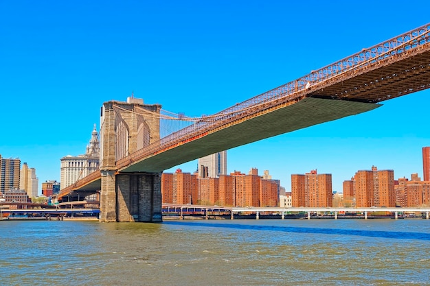 Vista dal traghetto sul ponte di Brooklyn sull'East River. Sullo sfondo c'è il Lower East Side a Manhattan di New York, USA.