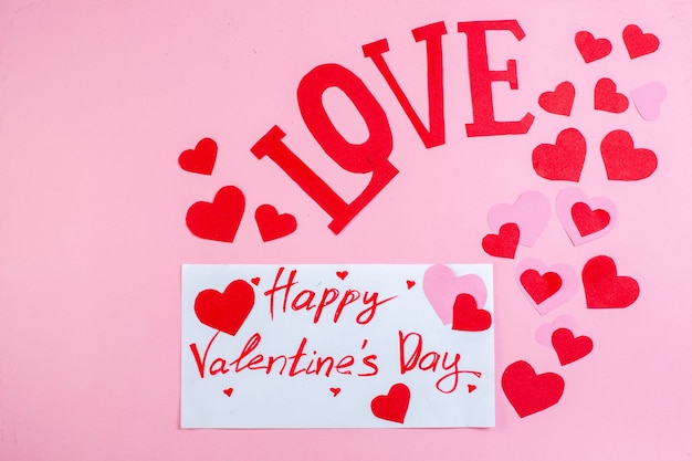 vista dall'alto adesivi cuore rosso buon san valentino scritto su carta amore in lettere maiuscole su sfondo rosa