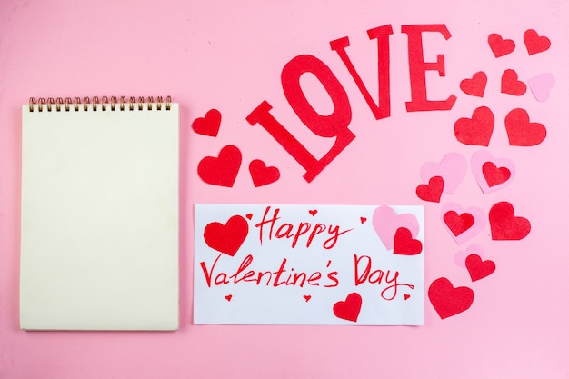 vista dall'alto adesivi cuore rosso buon san valentino scritto su carta con lettere d'amore taccuino su sfondo rosa