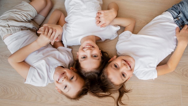 Vista dall'alto bambini sorridenti e sdraiati sul pavimento