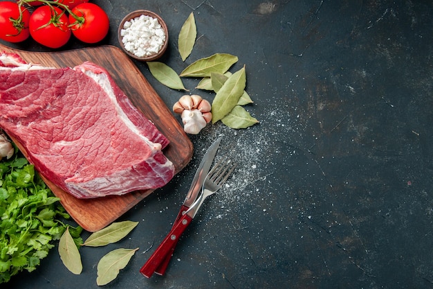 vista dall'alto carne cruda affettata con pomodori rossi e verdure. pasto di cottura della carne del cibo