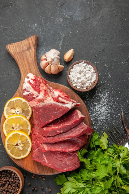 vista dall'alto carne fresca affettata con verdure e fette di limone