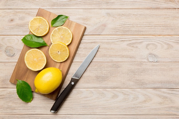 Vista dall'alto con spazio per la copia di limoni freschi e maturi sul tagliere Sfondo di cibo sano Sfondo elegante di fette di limone e limone con spremiagrumi e coltello sfondo colorato