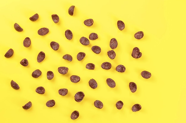 Vista dall'alto, cornflakes al cioccolato sparsi sul bordo giallo.