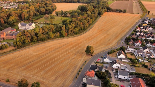 Vista dall'alto da un drone su un campo in autunno al tramonto Un bellissimo paesaggio con una carreggiata foresta ospita campi prati e un castello Viaggio