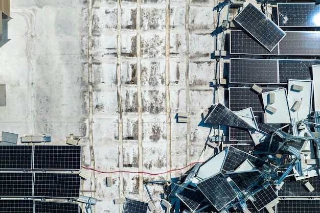 Vista dall'alto dei pannelli solari fotovoltaici distrutti dall'uragano Ian montati sul tetto di un edificio industriale per la produzione di elettricità ecologica verde Conseguenze del disastro naturale in Florida