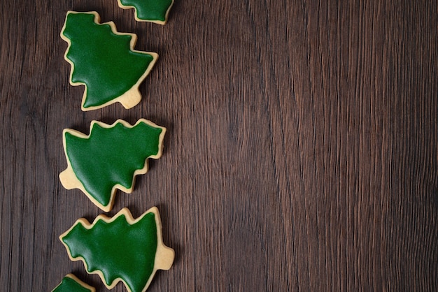 Vista dall'alto del biscotto di zucchero dell'albero di Natale decorato sul fondo della tavola in legno