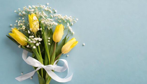 Vista dall'alto del bouquet di tulipani gialli e gipsofila bianca con nastro bianco per la composizione del Giorno della Donna