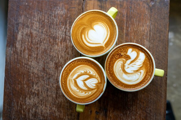 Vista dall'alto del caffè latte o cappuccino con una bellissima arte del latte sul tavolo di legno