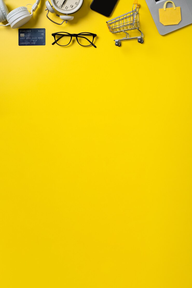 Foto vista dall'alto del concetto di shopping online con carta di credito, smartphone e computer isolato su sfondo giallo tavolo da ufficio.